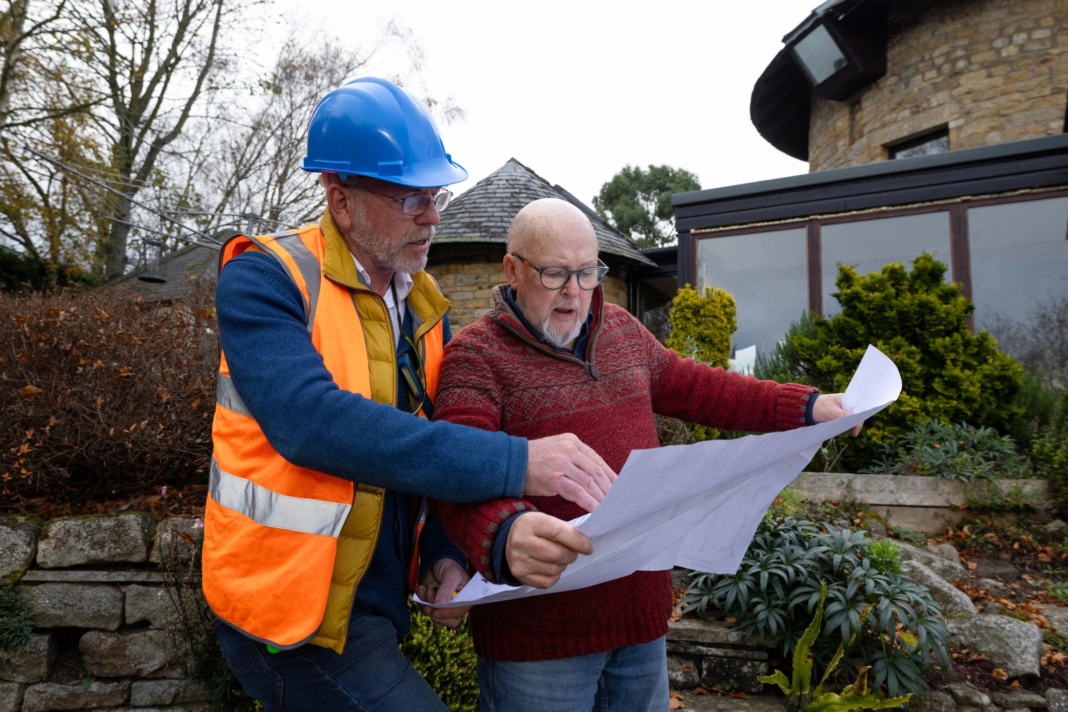 Contractor and client reviewing construction plans together